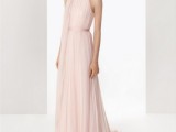 a blush fully pleated a-line wedding dress with a sash and an oversized fabric bloom on the shoulder