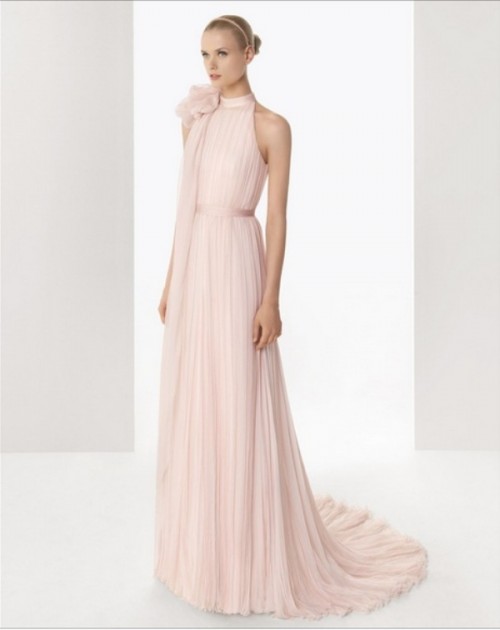 a blush fully pleated a-line wedding dress with a sash and an oversized fabric bloom on the shoulder