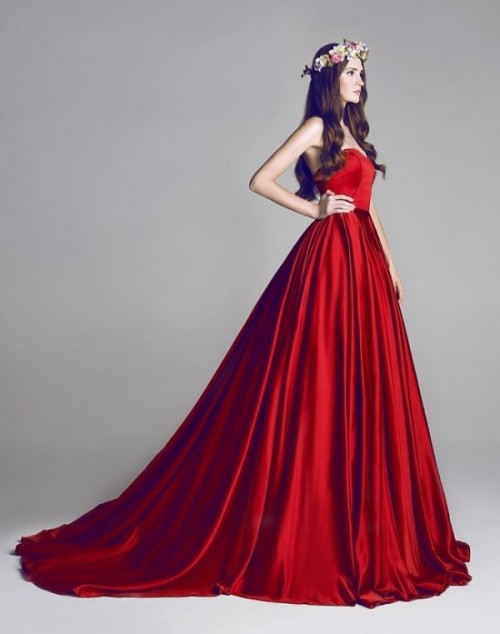 a red strapless wedding ballgown with a draped bodice and a pleated skirt with a train makes a statement with color and design