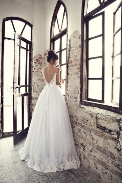 a vintage wedding ballgown with a full skirt, an open back, spaghetti straps and a lace bodice is wow