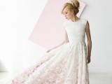 a modern romantic lace A-line wedding dress with a high low skirt, a high neckline, no sleeves and a pink underskirt is wow