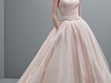 a blush wedding ballgown with a draped bodice and a layered skirt plus a romantic veil for a vintage-inspired look