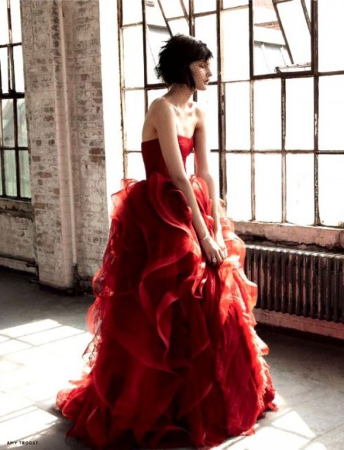 a red strapless wedding dress with a draped bodice and a layered and ruffled skirt is a bold and modern option to rock