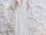 a romantic floral applique A-line wedding dress with a plunging neckline and long sleeves