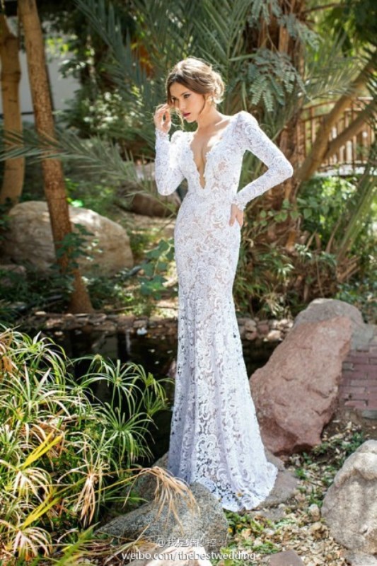 A lace sheath wedding dress with a plunging neckline and long sleeves is very sexy