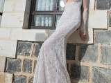 a white sheath lace wedding dress with a plunging neckline and long and sheer sleeves