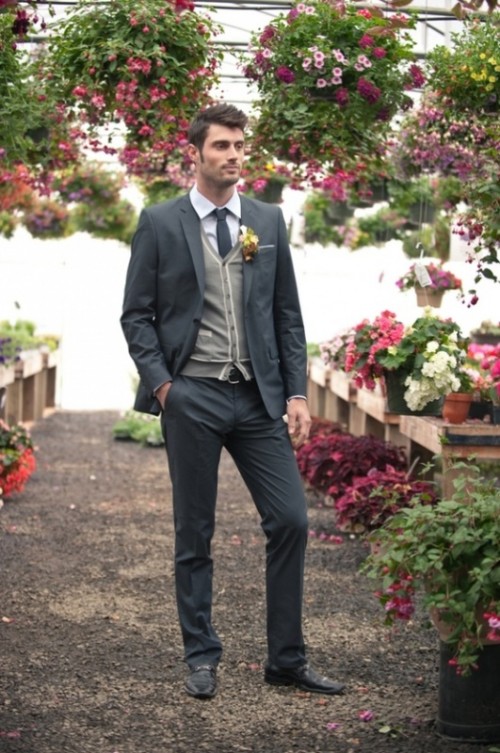 a creative layered groom's look with a graphite grey pantsuit, a light grey cardigan, a white shirt and a black skinny tie are a fantastic combo for a less formal wedding on a cold day