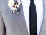 a grey checked suit, a white shirt, a black skinny tie and a white floral boutonniere are a chic and cool combo for a wedding