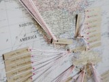 a map seating chart with twine, pins and tags is a stylish and cool modern idea for a travel-loving couple