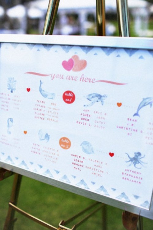 a pastel marine-inspired wedding seating chart with various sea creatures is a cool idea for a beach or coastal wedding