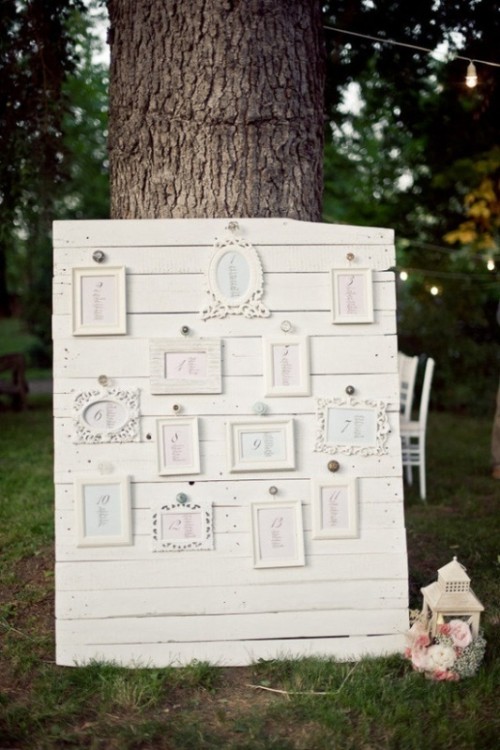 a vintage wedding seating chart in white with an arrangement of various refined frames is an elegant idea