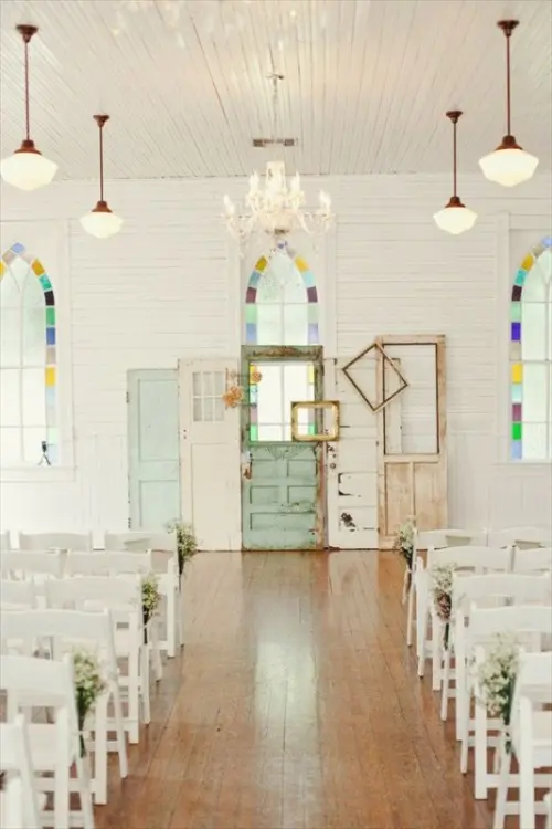 an arrangement of shabby chic neutral and pastel doors plus blooms is a cool idea for an indoor vintage wedding ceremony