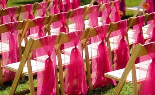 chairs with hot pink tulle on them look fun, bold and cool and infuse the wedding ceremony space with color