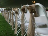 white chairs decorated with burlap roses and ribbons look very rustic and cool and add a cozy feel to the space
