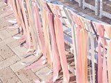 white chairs with pink, yellow and pastel ribbons on them look very nice, chic and delicate and bring a festive feel to the space