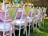 white chairs with colorful and printed ribbon decor plus blush peonies look fun, bright, cool and very festive-like