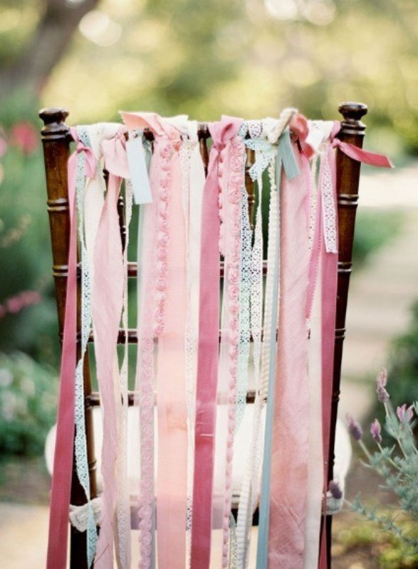 A dark stained chair with lots of pink fabric ribbons of various colors and with prints is a lovely and cool idea for a wedding
