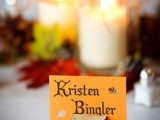 a tree stump with a card is a nice place card idea for a fall or winter woodland wedding