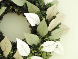 a creative seating chart for a fall or winter wedding – a boxwood wreath with paper cards shaped as leaves