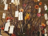 branches with bright leaves and blooms and tags with names hanging from them is a creative wedding seating chart idea
