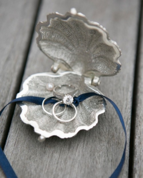 a silver shell with rings and a navy ribbon to hold them is a creative way to display your rings at the ceremony