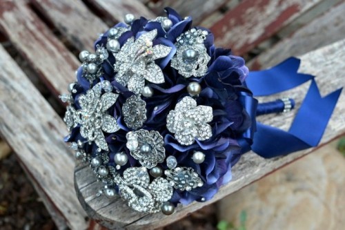 a bright wedding bouquet of navy ribbons and vintage brooches is a bold idea for a bride