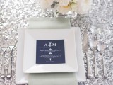 a chic tablescape with a silver sequin tablecloth, neutral blooms and a place setting with a navy menu