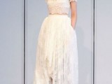 a refined bridal look with a two-piece wedding dress with a crop top and short sleeves and a high low skirt with a train is a lovely idea for a modern and chic bride