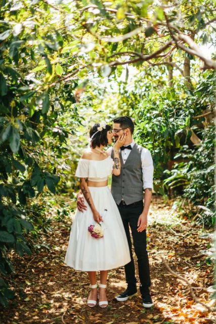 a relaxed bridal ensemble of an off the shoulder crop top and a midi skirt, white ankle strap shoes and a floral crown are amazing for a relaxed wedding