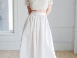 a delicate and chic bridal look with an applique crop top and a plain pleated skirt plus a red lip and neutral shoes and a messy hairstyle is chic