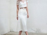 a simple and lovely two-piece wedding dress with floral applique, a crop top with short sleeves and a midi skirt plus neutral shoes for a more casual wedding