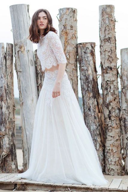 a stylish modern bridal look with a lace crop top with long sleeves and a matching skirt with a lace waist and a plain part and train is amazing