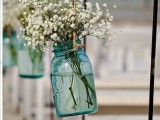 blue jars with baby’s breath to mark an aisle at a blue beach wedding ceremony