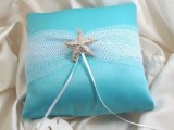 a blue pillow with net, a starfish accent and ribbons for a your rings at the beach wedding