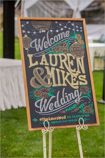 a black chalkboard sign with colorful calligraphy and in a stained frame is a lovely decoration for a modern and bold wedding