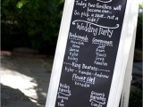 a black chalkboard sign in white frames and with calligraphy is a lovely idea that can fit many relaxed wedding themes