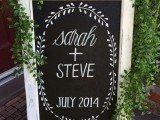 a chalkboard sign with white framing and greenery is a lovely idea for a rustic wedding, you can style one yourself