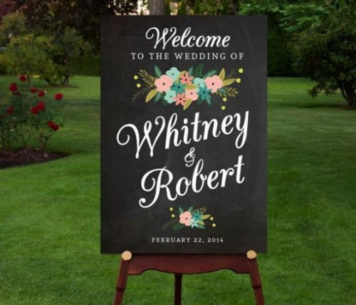 a black chalkboard sign with calligraphy and painted blooms is a lovely idea for a modern wedding, it may add color and interest to the space