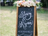 a chalkboard sign with calligraphy and fresh neutral blooms and greenery on top is a lovely idea for a rustic wedding