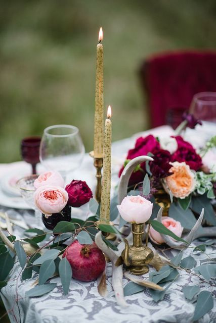 refined fall wedding tablescape with blush and burgundy blooms, greenery, gold candles in gold candleholders and pomegranates is a chic idea