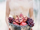 an oversized silver bowl with pomegranates and grapes is a beautiful and delicious-looking idea for a fall wedding with a decadent feel