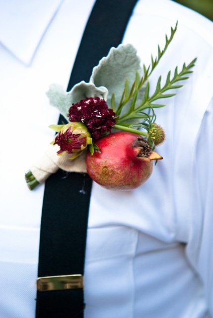 a fall wedding boutonniere with burgundy blooms, greenery, a pomegranate is a lovely idea for a fall boho wedding