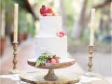 a white textural buttercream wedding cake topped with berries, greenery and a pomegranate is a gorgeous idea for a fall wedding