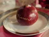 a pomegranate with a gold calligraphy name will function as a card and as a wedding favor at a fall or winter wedding