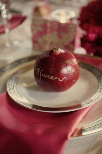 a pomegranate with a gold calligraphy name will function as a card and as a wedding favor at a fall or winter wedding