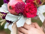 a super bright wedding bouquet of deep red and fuchsia blooms, pomegranates and pale leaves is a fantastic idea for a fall wedding