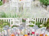 a bright and fun backyard wedding tablescape with candle lanterns, amber glasses, gold cutlery, greenery, bright blooms and neutral linens is amazing for summer