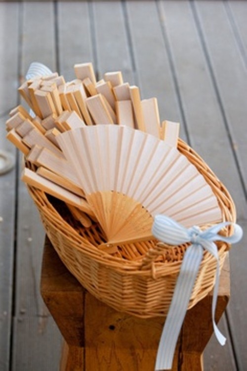 a basket with fans, the latter are nice beach wedding favors to avoid overheating, you may add personalized touches to them