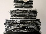 a black and white ruffle wedding cake with white roses on tp for a chic and contrasting vintage-infused wedding