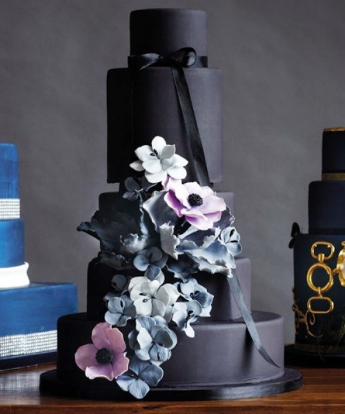a matte black wedding cake with black ribbon, with pastel blue and pink sugar blooms is a refined and chic idea for a dark romance or Halloween wedding